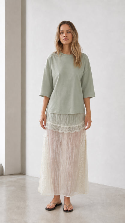 Front view of woman wearing sage green relaxed tee and matching skirt set