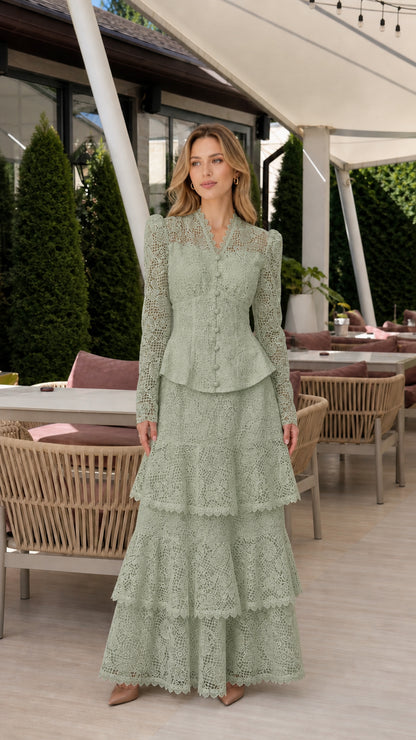 Front full view of woman wearing sage green long-sleeve lace peplum tiered maxi dress