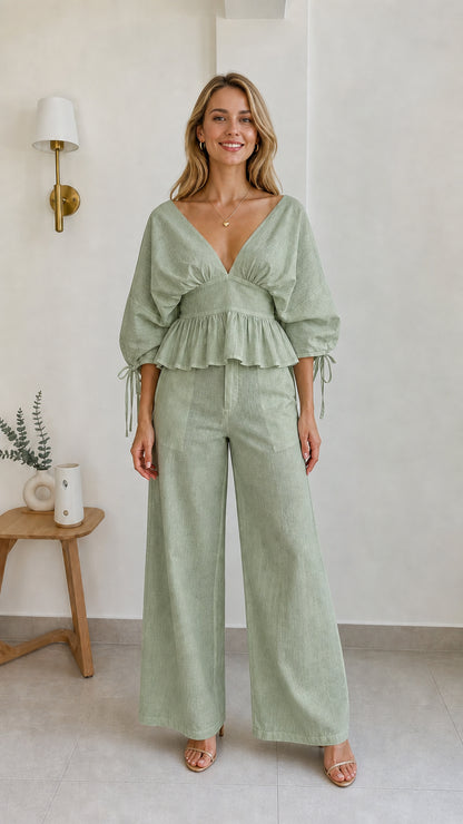 Model wearing sage green two-piece peplum and wide-leg pants set