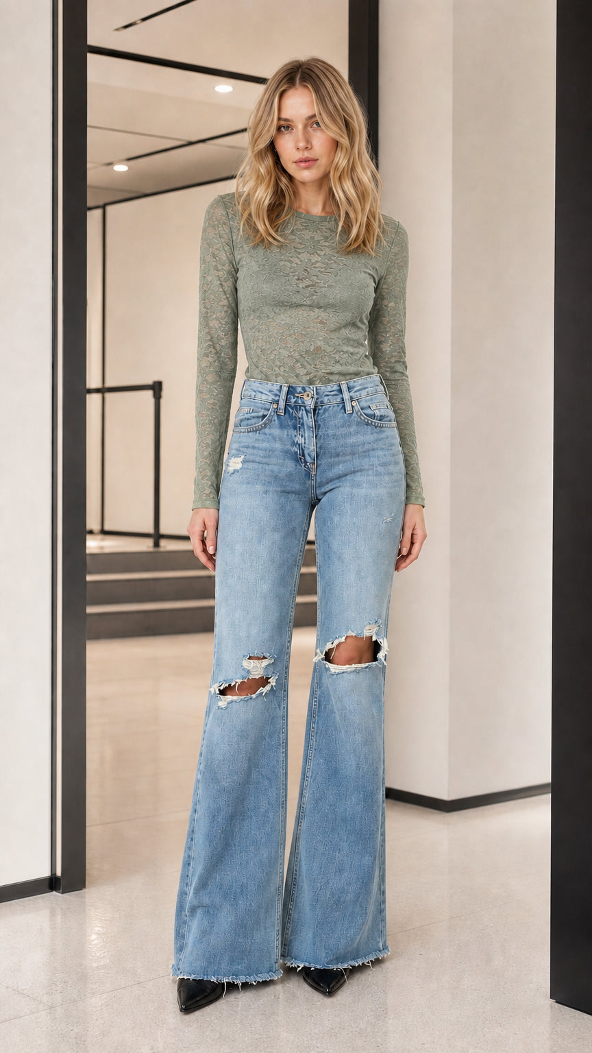 Model wearing sage green long-sleeve sheer lace top with flare jeans