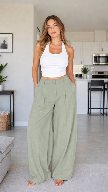 Full front view of model wearing sage green high waisted pleated wide leg trousers