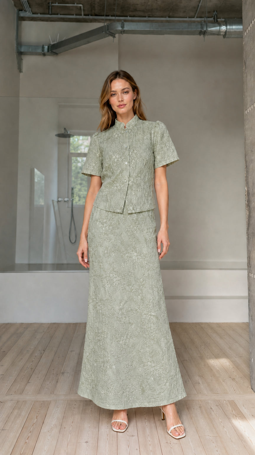 Model wearing sage green floral embroidered short-sleeve blouse and maxi skirt set