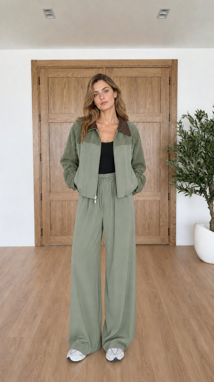 Model wearing sage green two-piece jacket and wide leg pants set