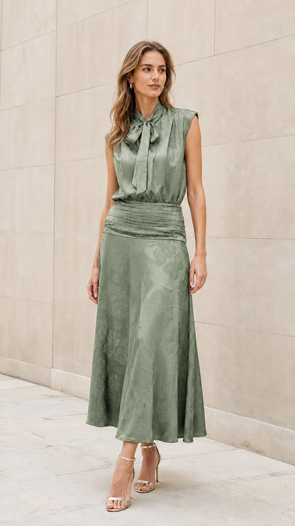 Front view of model wearing sage green tie-neck midi dress