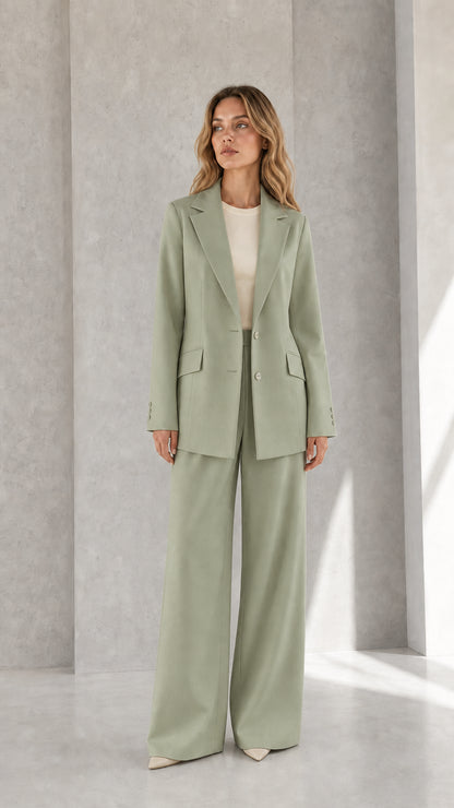 Woman wearing sage green tailored blazer and flowing wide-leg pants set