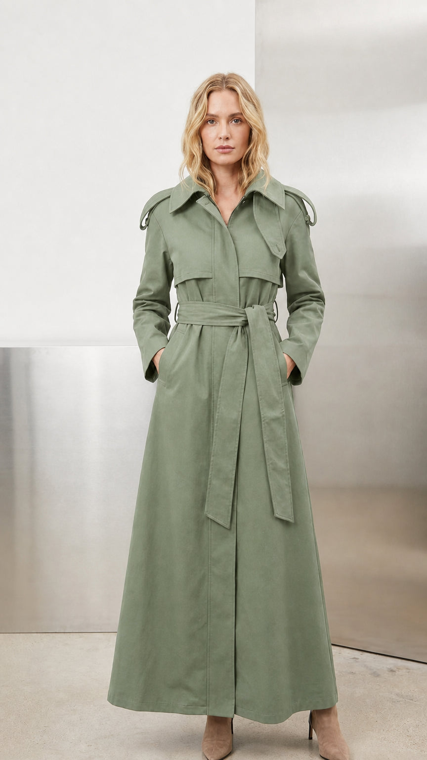 Model wearing muted sage green belted maxi trench coat