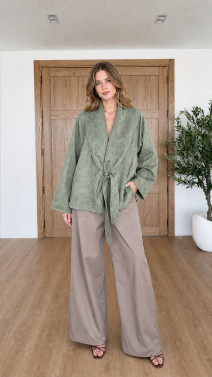 Front view of woman wearing Sage Green faux suede tie-front wrap jacket