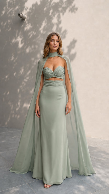 Model showcasing sage green evening gown and attached cape