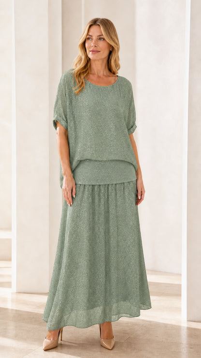 Model wearing sage green shimmer two-piece maxi skirt set