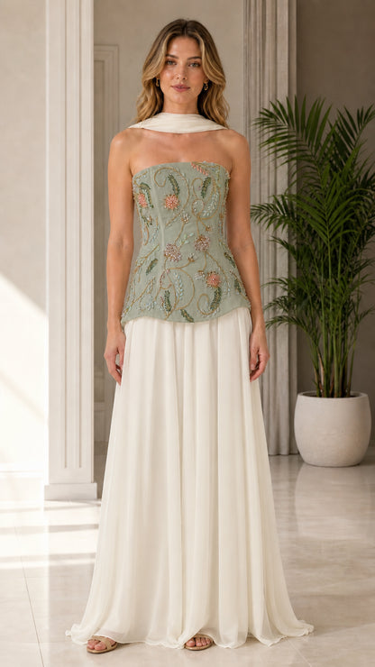 Model wearing sage green floral beaded corset bodice with ivory pleated maxi skirt