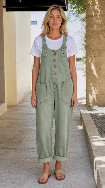 Front view of model wearing sage green denim overalls