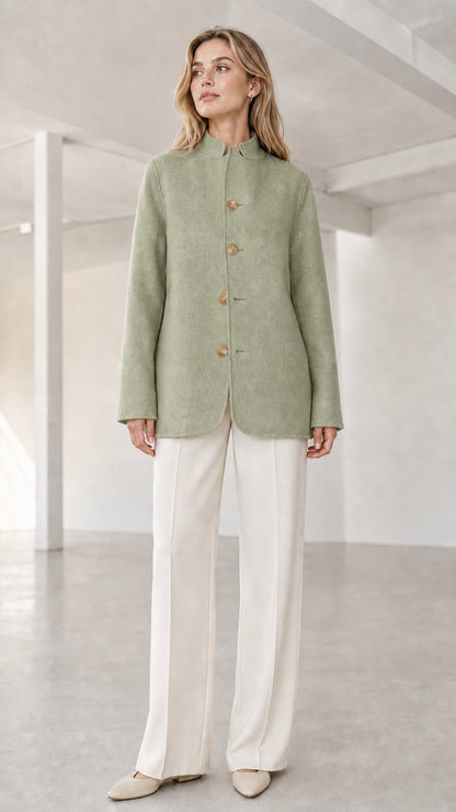 Front view of model wearing sage green stand collar button coat