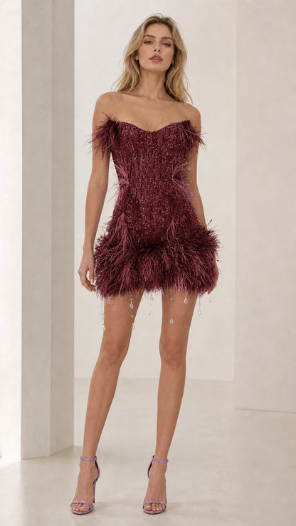 Model wearing burgundy feather trim sequin mini dress