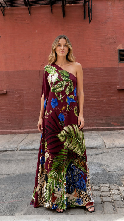 Model wearing burgundy tropical print one-shoulder maxi dress