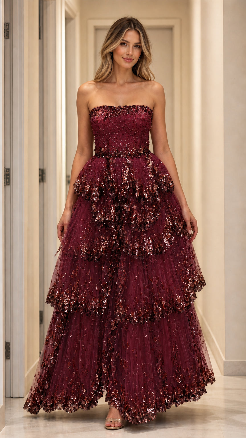 Model wearing burgundy strapless tiered sequin gown