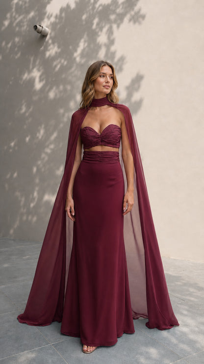 Model in rich burgundy formal two-piece dress with cape