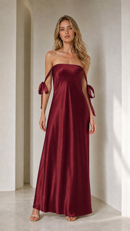 Model wearing burgundy satin strapless maxi dress