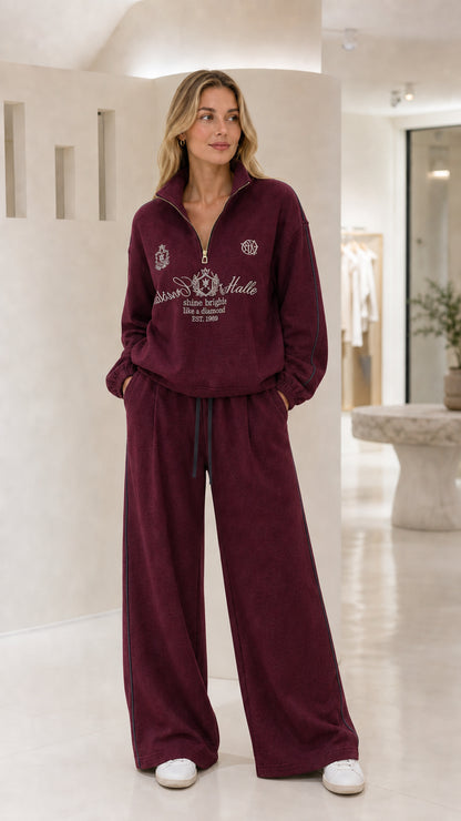 Woman wearing the burgundy quarter-zip wide-leg tracksuit set