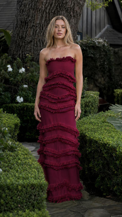 Model wearing burgundy tiered fringe strapless maxi dress