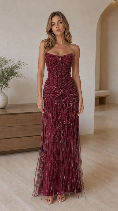 Full front view of burgundy strapless beaded fringe formal gown