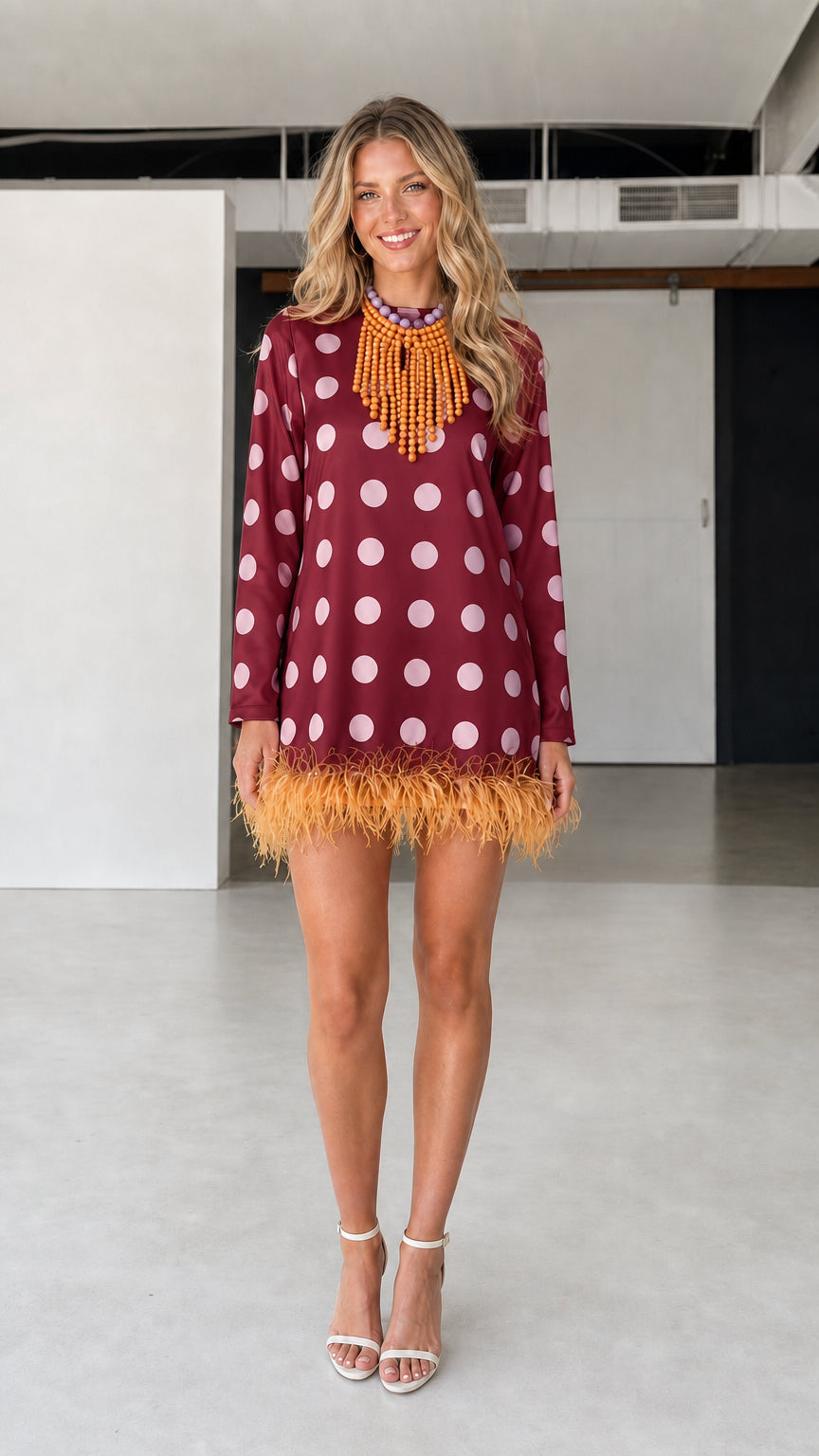 Model wearing burgundy polka dot feather hem dress