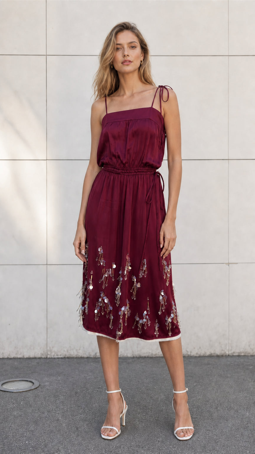 Front view of model wearing burgundy satin embellished midi slip dress
