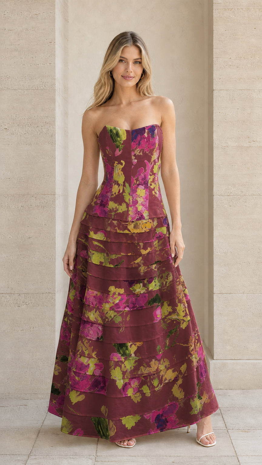 Model wearing burgundy floral strapless tiered formal evening dress