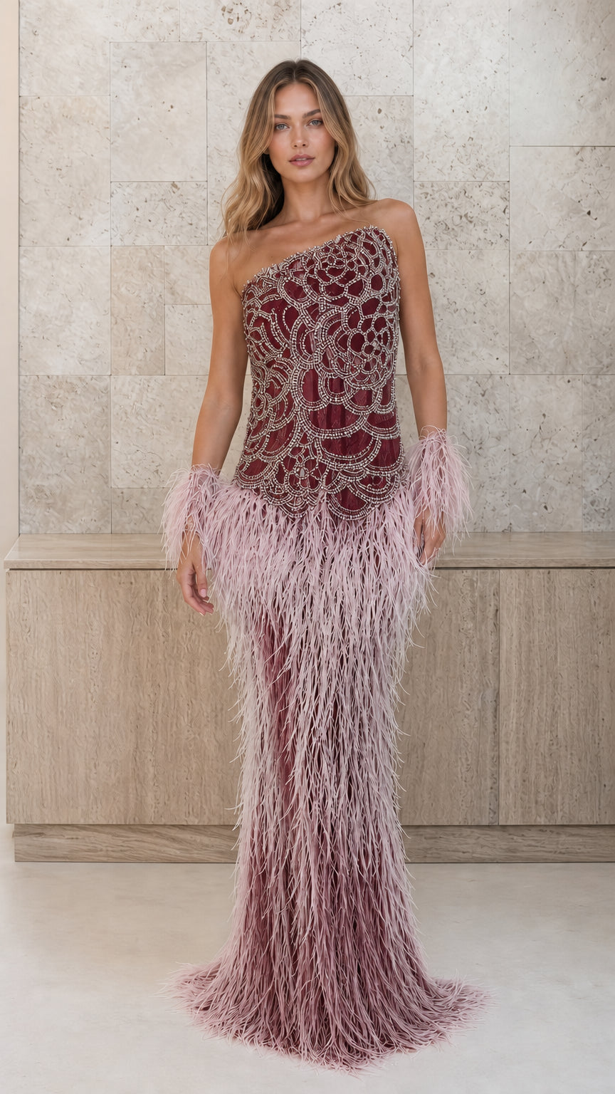Burgundy beaded one-shoulder gown with ombre feather skirt and cuffs