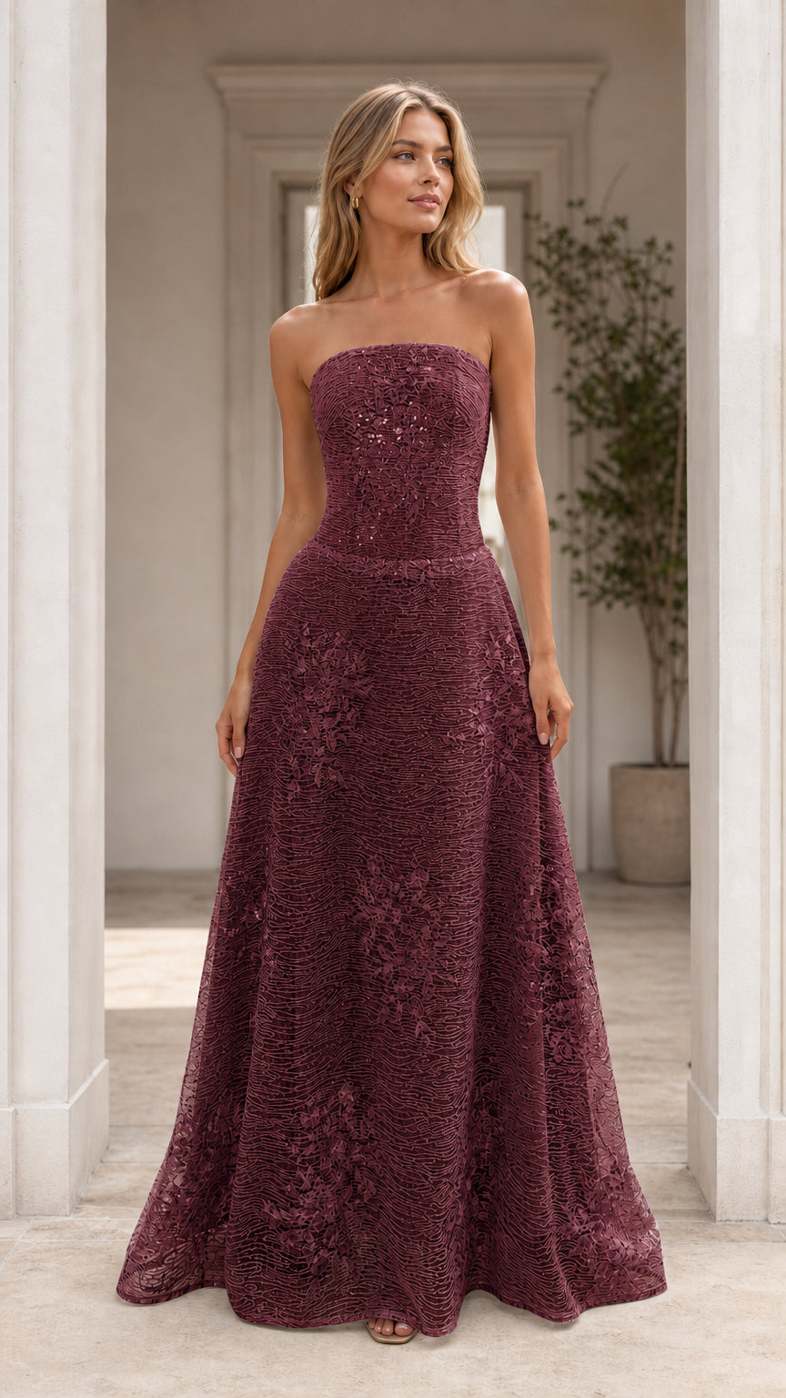 Front view of model wearing burgundy strapless formal evening dress
