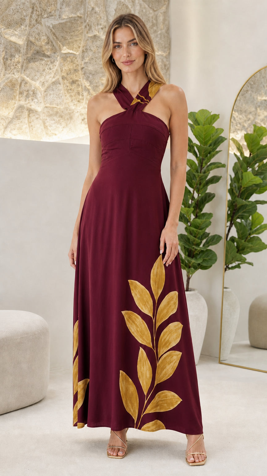 Front view of woman wearing Burgundy halter maxi dress with golden leaf print