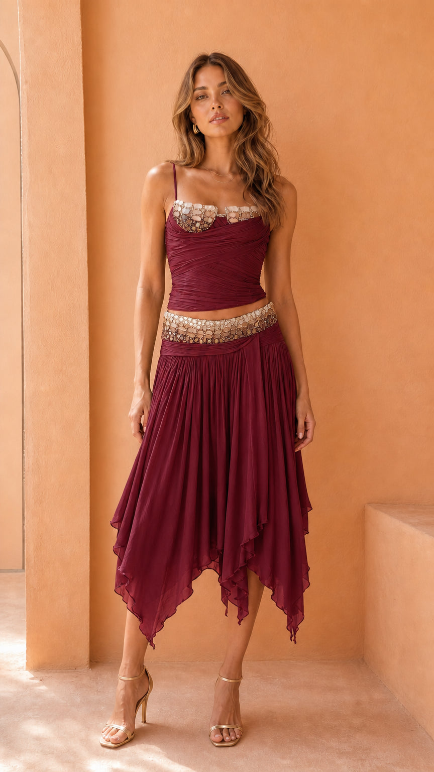 Model wearing burgundy embellished corset top and skirt set