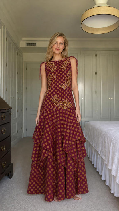 Model wearing burgundy polka dot tiered maxi dress
