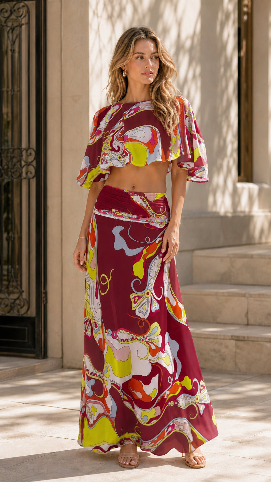 Model wearing burgundy variant of the abstract print two-piece set