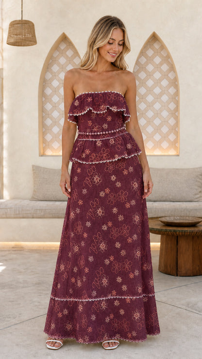 Woman wearing burgundy floral embroidered strapless maxi dress