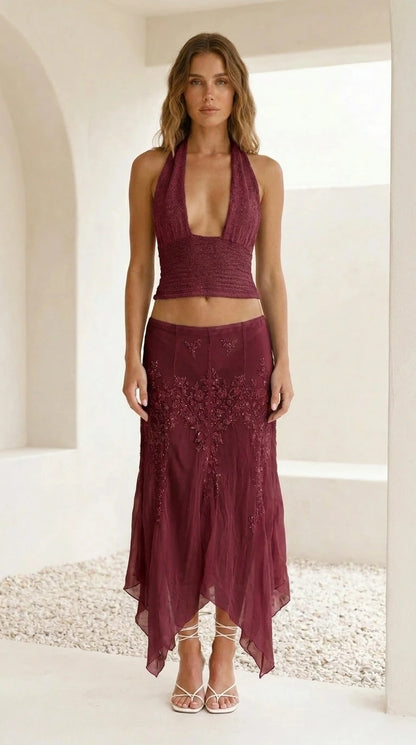 Model wearing burgundy embroidered halter crop top and skirt set