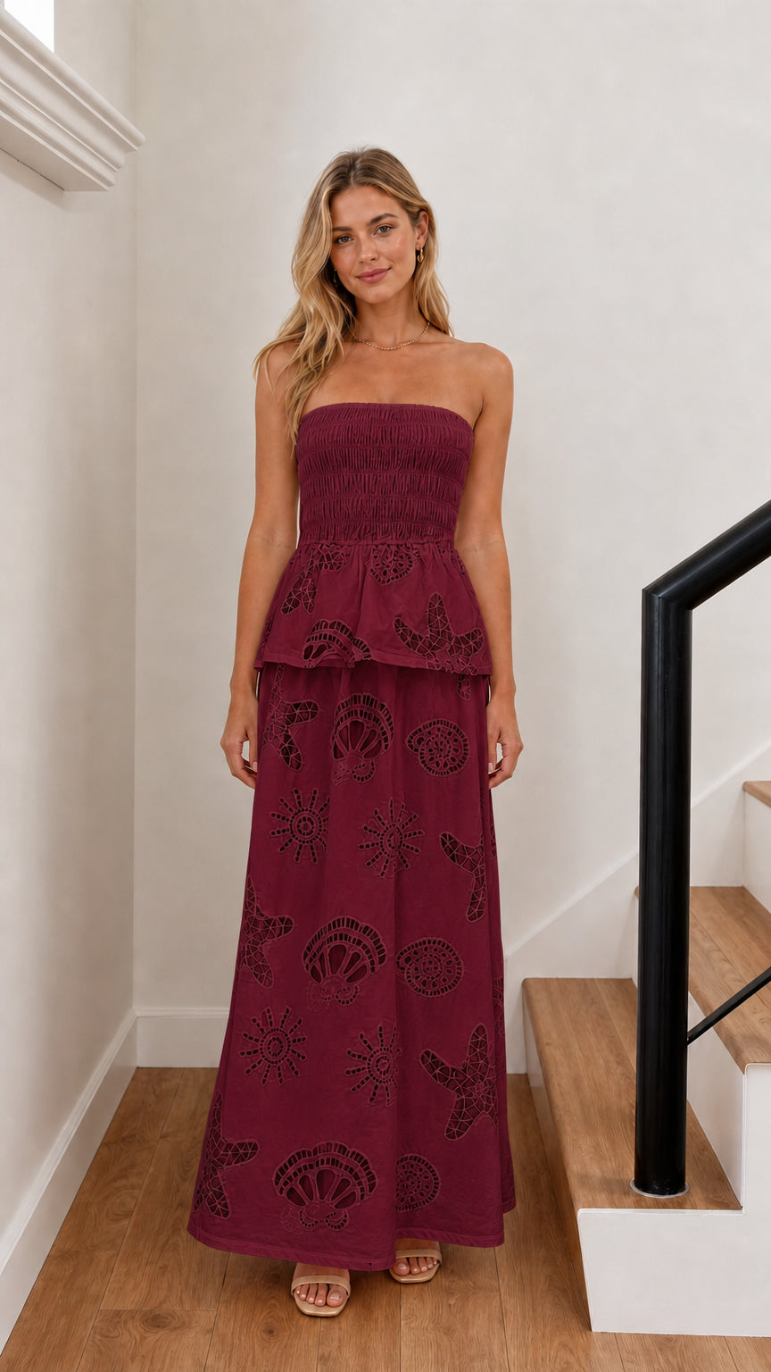 Model wearing burgundy strapless embroidered maxi dress