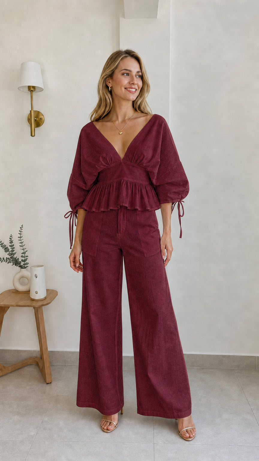 Model wearing burgundy two-piece peplum and wide-leg pants set