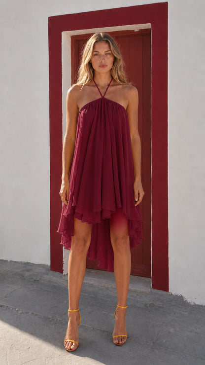 Front view of woman wearing burgundy halter neck high-low dress