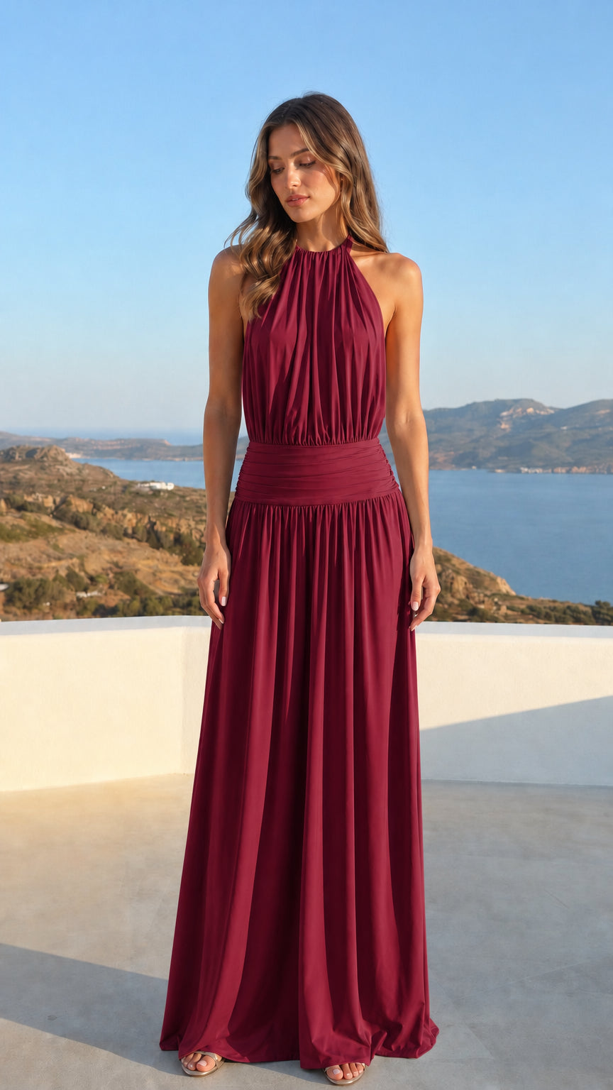 Woman wearing a burgundy wine red halter neck backless evening maxi dress