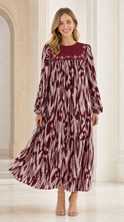 Woman wearing wine red and cream pleated maxi dress with floral yoke embroidery