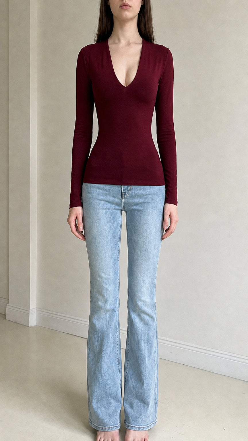 Front view of woman wearing burgundy deep v-neck long sleeve top