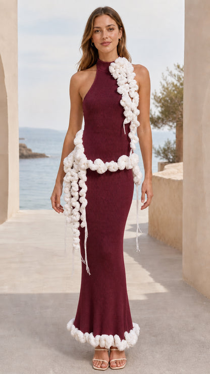 Full-length view of burgundy wine halter neck ribbed knit maxi dress with cream pom pom trim