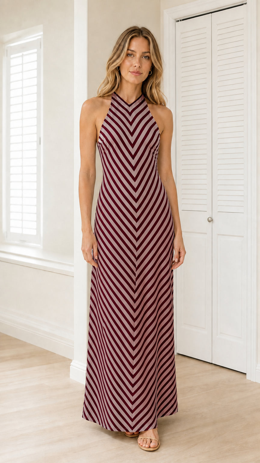 Front view of model wearing burgundy striped halter maxi dress
