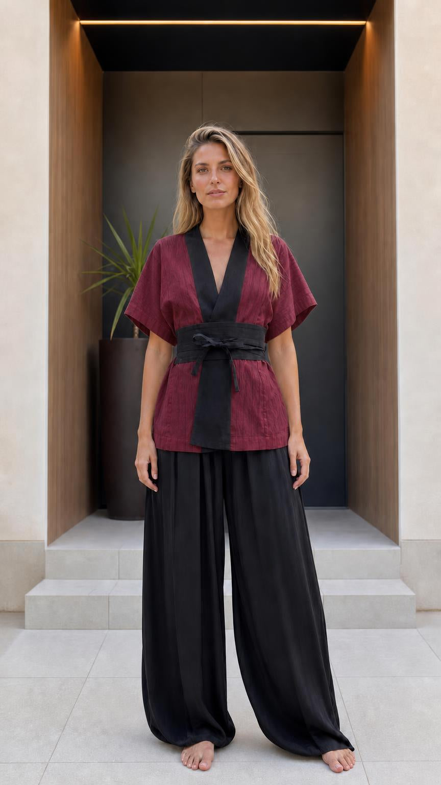 Front view of woman wearing burgundy kimono top and black wide-leg pants set