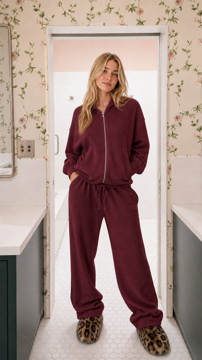 Model wearing burgundy wine two-piece ribbed knit zip-up hoodie and wide-leg lounge set