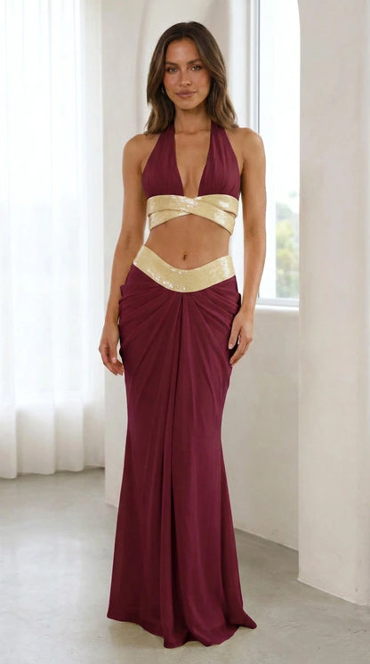 Model wearing burgundy sequin halter two-piece maxi dress