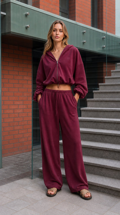 Woman wearing a burgundy cropped hoodie and wide-leg pants set