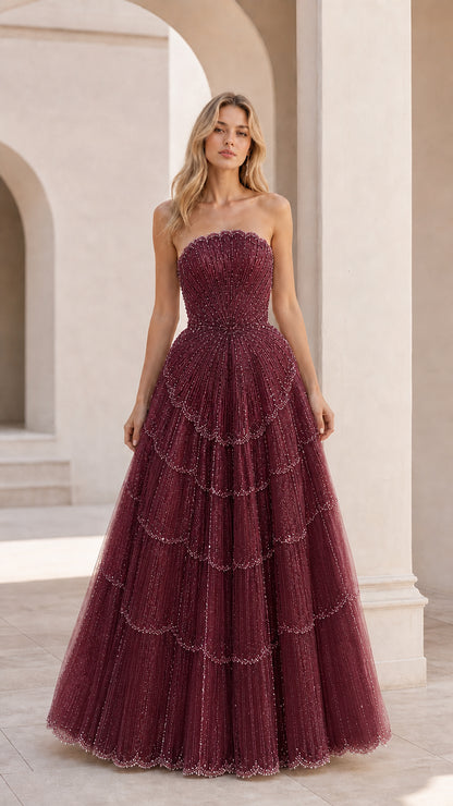 Front view of burgundy strapless tiered evening gown