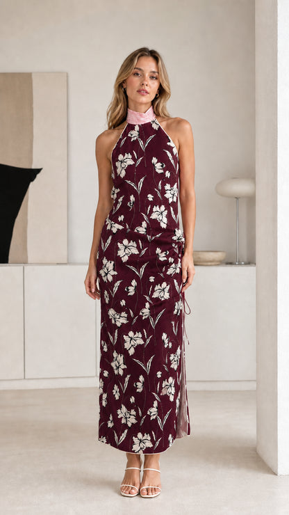 Woman wearing burgundy floral halter maxi dress