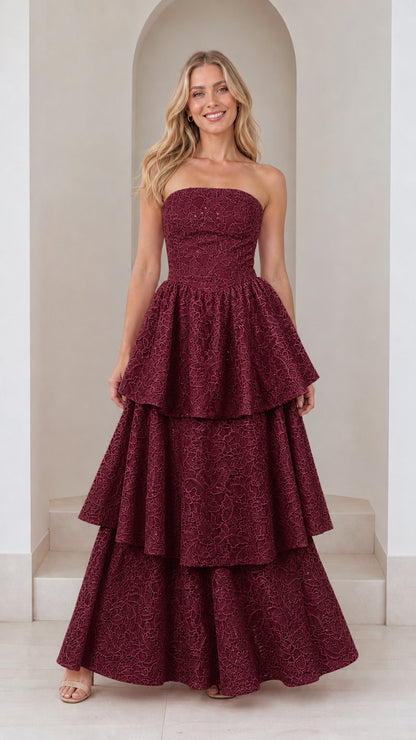Front view of model in burgundy strapless tiered maxi dress